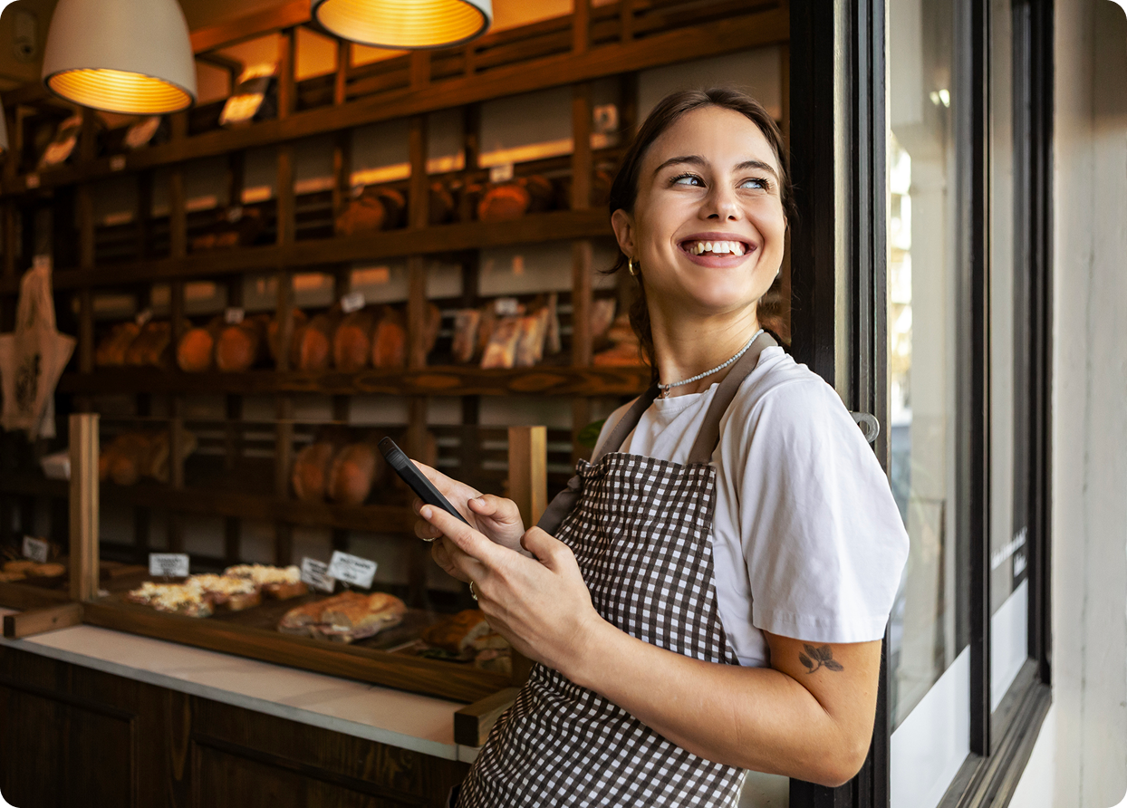 Bakery worker smiling with a phone