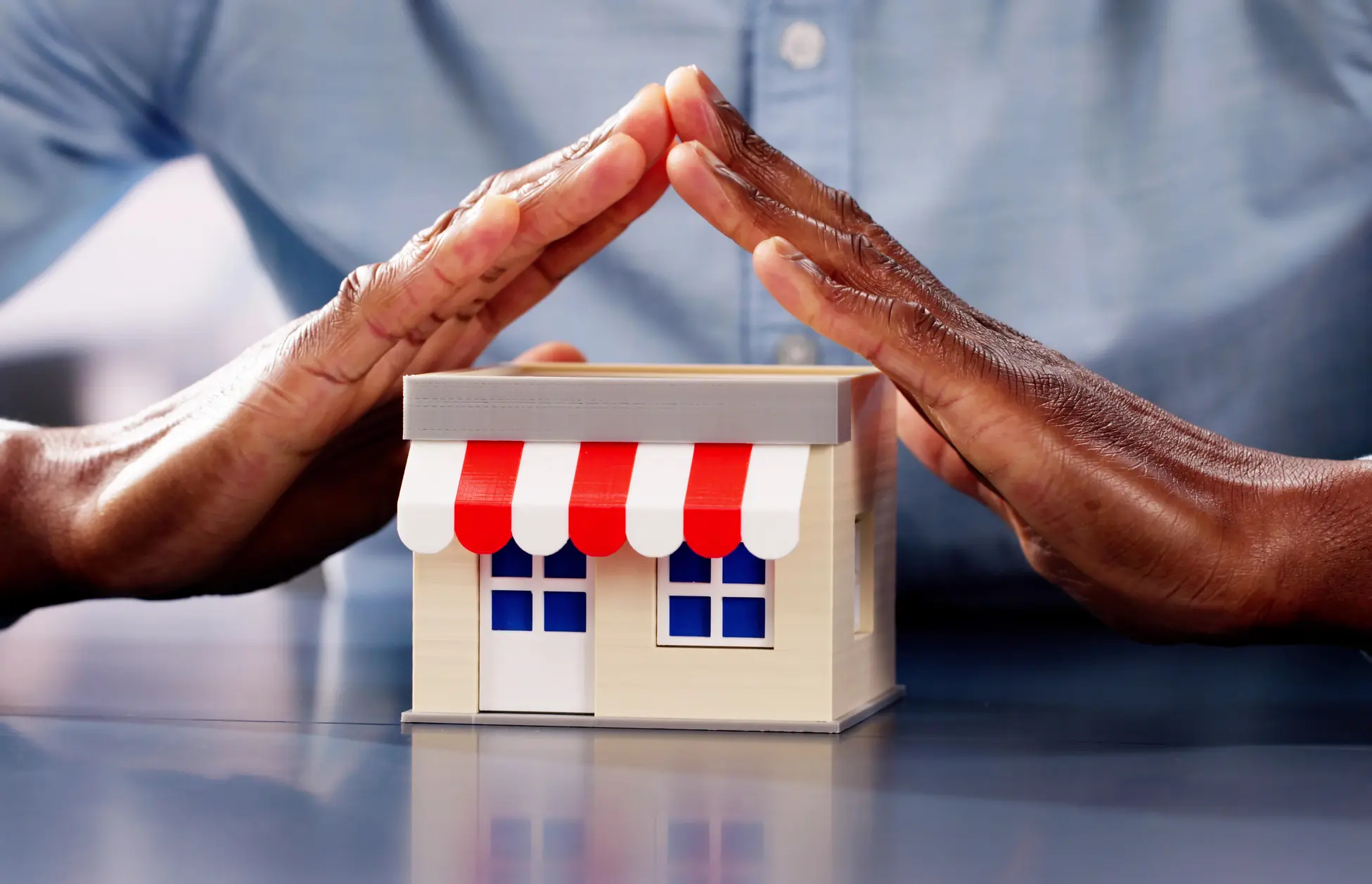 Business security concept with hands covering shop
