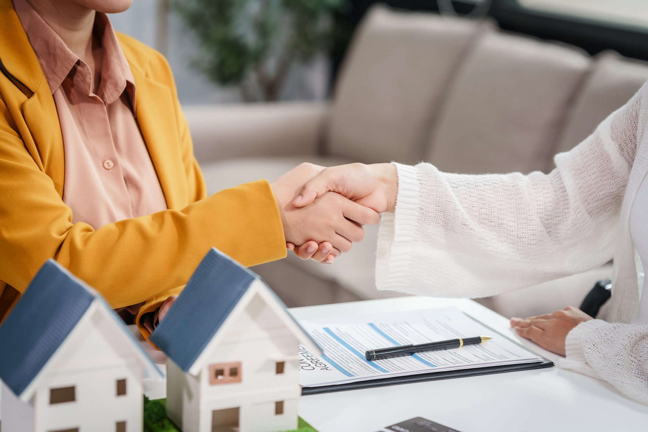 Business handshake with model houses