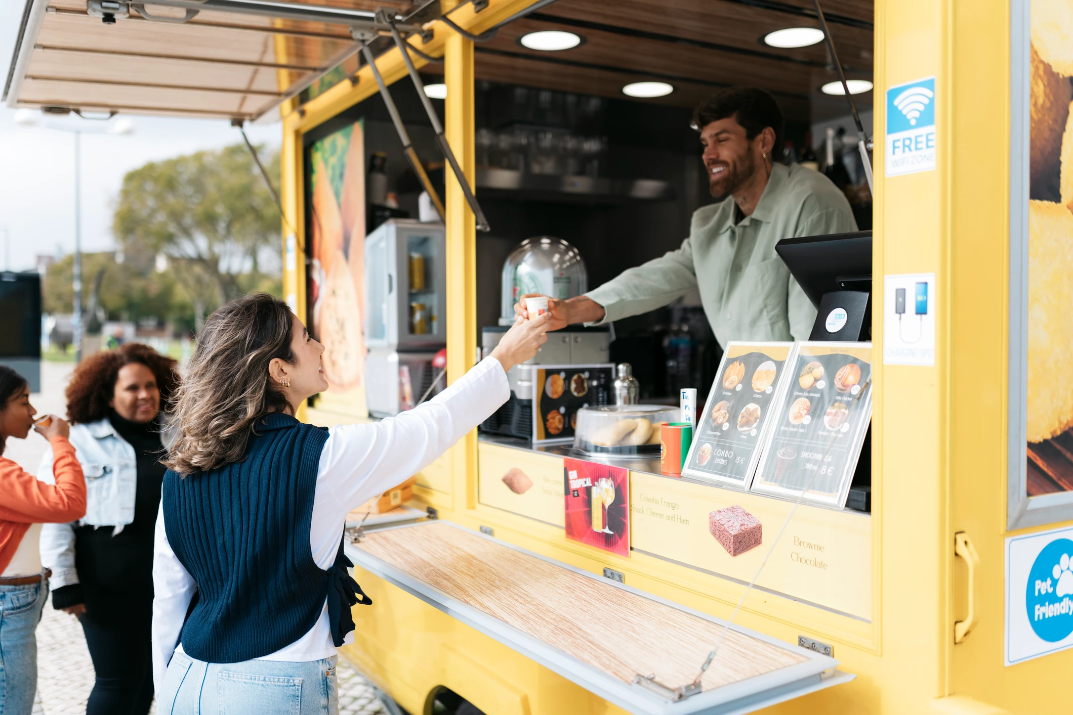 People enjoying drinks at yellow food truck